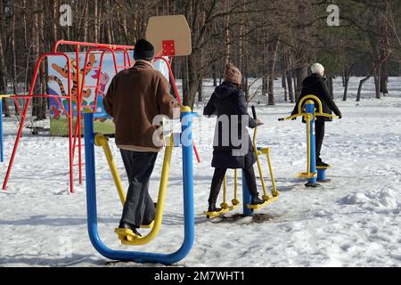 Kiew, Ukraine 25. Februar 2021: Im Winter gehen Menschen im Stadtpark auf dem Sportplatz Sport treiben Stockfoto