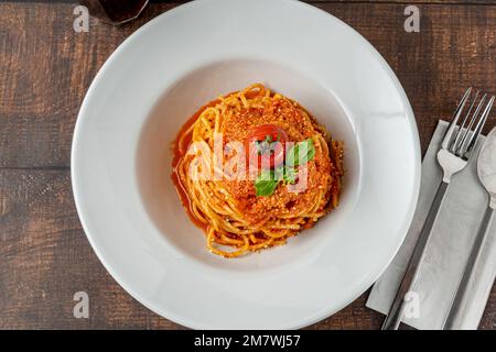 Pasta mit Käse und Tomatensauce auf einem weißen Porzellanteller Stockfoto