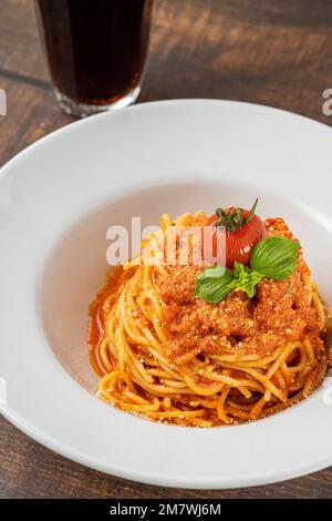 Pasta mit Käse und Tomatensauce auf einem weißen Porzellanteller Stockfoto