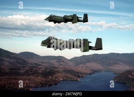 Eine Air-to-Air-Seitenansicht von zwei A-10 Thunderbolt II-Flugzeugen aus dem 174. Tactical Fighter Wing, Syracuse, New York, während sie über die Adirondack Mountains fliegen. Land: Unbekannt Stockfoto