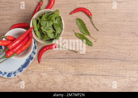 Frische Chili, Eier, Basilikum auf Holzhintergrund, Rahmen für Text. Stockfoto