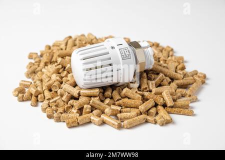 Holzkugeln mit Thermostat. Thermostatischer Ventilkopf isoliert auf weißem Hintergrund. Erneuerbare Wärmequelle. Biokraftstoff. Ökologischer Brennstoff aus Bi Stockfoto