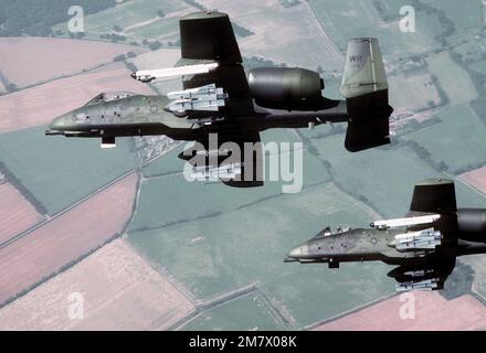 Eine Luft-Luft-Ansicht von links unter zwei A-10 Thunderbolt II-Flugzeugen, die sich rechts über RAF Bentwaters befinden. Die Flugzeuge aus dem taktischen Kampfflugflügel 81. transportieren jeweils vier AGM-65B Maverick Scene Vergrößerungs-Raketen und eine AN/ALQ-119 elektronische Gegenmaßnahmen-Kapsel. Land: England / Großbritannien (eng) Stockfoto