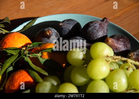 Verschiedene Bio-Früchte vom lokalen Bauernmarkt auf einem Teller auf alter Holzfläche. Nahaufnahme. Hintergrund: Obst der Saison. Gesunde Ernährung, einfacher Lebensstil Stockfoto