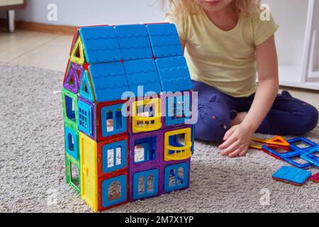 Ein hausgemachter magnetischer Konstruktor. Gesichtsloser Kinderhintergrund-Baumeister Stockfoto