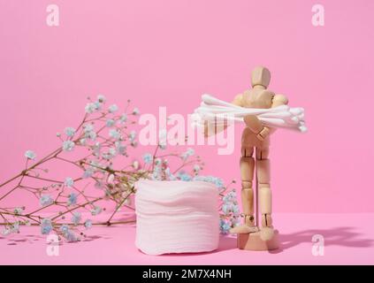 Runde kosmetische Polster aus Baumwolle und Wattestäbchen auf pinkfarbenem Hintergrund Stockfoto