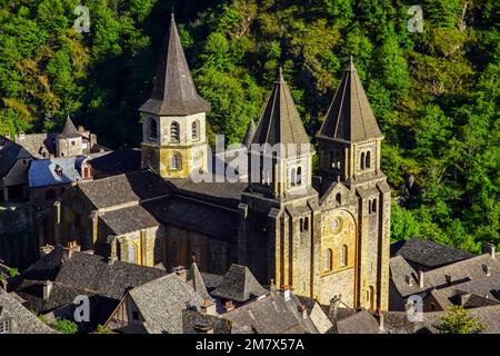 Erhöhte Aussicht auf das Dorf Conques und die Abteikirche Sainte-Foy, das Juwel romanischer Architektur, Occitanie, Frankreich. Stockfoto