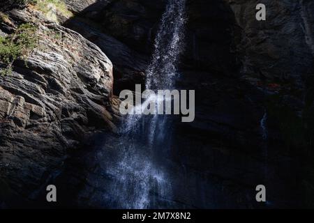 Wasserläufe aus reinem Alpenwasser aus dem Lillaz-Wasserfall (Cascate di Lillaz) brechen in Millionen kleiner Spritzer auf rauen Granitfelsschichten Stockfoto