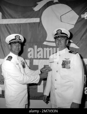 CDR David T. Wagner (links) klebt während der Zeremonie zum Kommandowechsel für das Angriffsgeschwader 52 (VA-52) das Kommandoabzeichen an den neuen Befehlshaber, CDR Bruce V. Woods. Basis: Marine Air Station Whidbey Island Staat: Washington (WA) Land: Vereinigte Staaten von Amerika (USA) Stockfoto