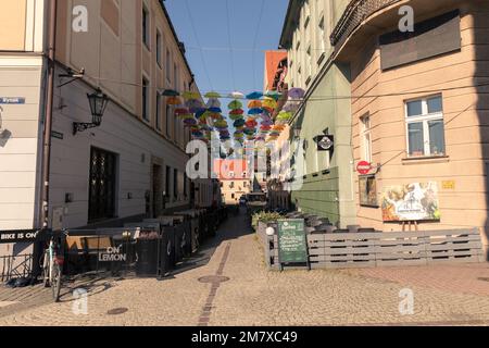 Über der Straße hing ein farbenfroher Sonnenschirm. Stockfoto