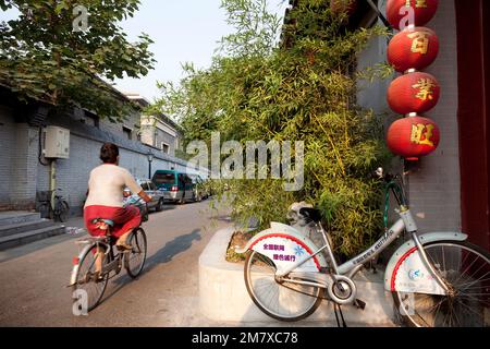 China, Peking - 17. August 2010. Ein Chinese fährt mit seinem Fahrrad früh am Morgen zur Arbeit durch das alte Hutong de City Stockfoto