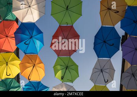 Über der Straße hing ein farbenfroher Sonnenschirm. Stockfoto