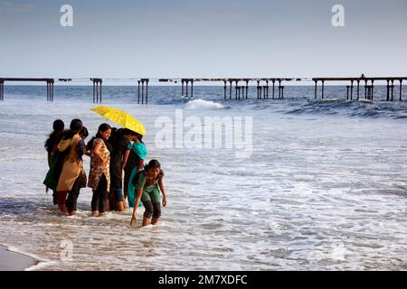 Allepey, Indien - 6. September 2012. Viele indische Touristen kommen zum Strand, um zu spazieren oder zu schwimmen. Einer von ihnen will das Wasser mit ihren Händen berühren Stockfoto