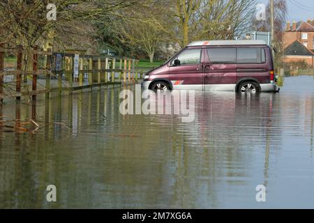 Tewkesbury, Gloucestershire, Großbritannien – Mittwoch, 11. Januar 2023 – Überschwemmungen rund um die historische Stadt Tewkesbury mit einem Fahrzeug umgeben von Wasser auf einem Parkplatz – die Stadt liegt am Zusammenfluss des Flusses Avon und des größeren Flusses Severn und unterliegt derzeit einer Hochwasserwarnung der Umweltbehörde. Die Prognose sieht weitere Niederschläge vor. Foto Steven May/Alamy Live News Stockfoto