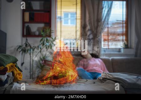 Bügeleisen auf dem Bügelbrett mit heißen Flammen. In unscharfem Hintergrund schläft die Frau auf dem Sofa. Konzept der Brandgefahr durch elektrische Haushaltsgeräte. Stockfoto