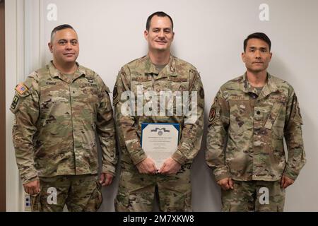 USA Air Force Staff Sgt. Isaac McMillan (Zentrum) erhält eine Ehrenmedaille bei U.S. Armeebrig. General Moses Kaoiwi Jr., Befehlshaber der Hawaii Army National Guard und US Oberstleutnant Glen Hayase der Luftwaffe für seine Bemühungen, das erste Cyber-Mission-Assurance-Team der Hawaii National Guard am 14. Mai 2022 in Fort DeRussy, Hawaii, aufzustellen. McMillan unterstützte ein Pilotprogramm des National Guard Bureau von Oktober 2018 bis März 2020. In diesem Zeitraum entwickelte das gemeinsame Team von Cyberspezialisten neue Methoden zur Unterstützung kritischer Netzwerkinfrastrukturen für Behörden und zivile Netzwerke Stockfoto