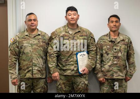 USA Air Force Staff Sgt. Marc Masuno (Zentrum) erhält eine Ehrenmedaille der USA Armeebrig. General Moses Kaoiwi Jr., Befehlshaber der Hawaii Army National Guard und US Oberstleutnant Glen Hayase der Luftwaffe für seine Bemühungen, das erste Cyber-Mission-Assurance-Team der Hawaii National Guard am 14. Mai 2022 in Fort DeRussy, Hawaii, aufzustellen. Masuno unterstützte von Oktober 2018 bis März 2020 ein Pilotprogramm des National Guard Bureau. In diesem Zeitraum entwickelte das gemeinsame Team von Cyberspezialisten neue Methoden zur Unterstützung kritischer Netzwerkinfrastrukturen für staatliche und zivile Netzwerke. Stockfoto