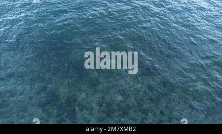 Luftaufnahme der Meeresoberfläche. Türkisfarbener Blick auf das Wasser aus einem hohen Winkel. Stockfoto
