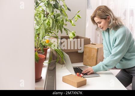 Nahaufnahme eines weiblichen Online-Shops, Inhaber eines kleinen Unternehmens, Unternehmer, der Verpackungspakete nach dem Versand vorbereiteter Versandkarton auf dem Tisch vorbereitet Stockfoto