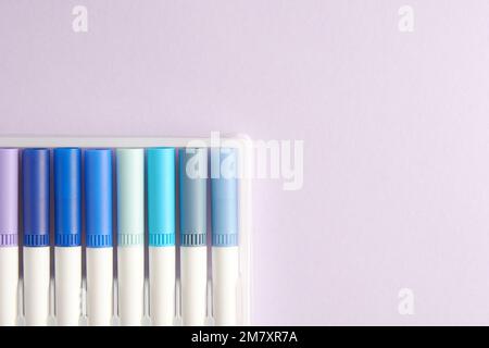 Blaue Aquarellmarkierungen zum Skizzieren isoliert auf einem violetten Hintergrund. Malen und Kunst Hobby-Thema. Platz für Text kopieren Stockfoto