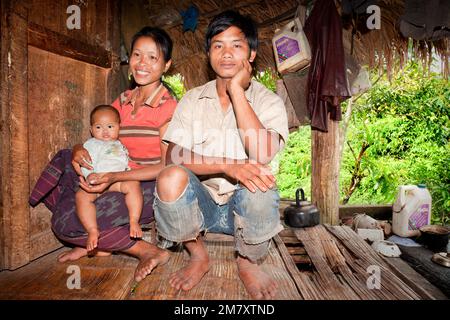 Luang Nam Tha, Laos, 19. Juli 2009. Am Eingang zu Ihrem Haus posiert eine Familie ethnischer Khamu für ein Porträt, das einen Teil des Weges und lebendige Tiere zeigt Stockfoto