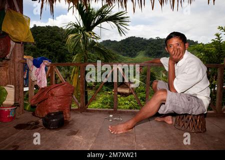 Luang Nam Tha, Laos, 19. Juli 2009. In einem Dorf des ethnischen Khamu im Norden von Laos ruhte sich nach einem harten Arbeitstag ein Bauer auf der Veranda seines Hauses aus Stockfoto