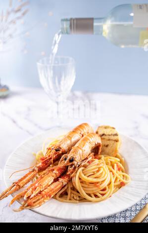 Ein Teller mit Meeresfrüchten für den festlichen Tisch. Pasta mit norwegischem Hummer und Weißwein. Essen für Feinschmecker. Geben Sie Platz für Text frei. Stockfoto