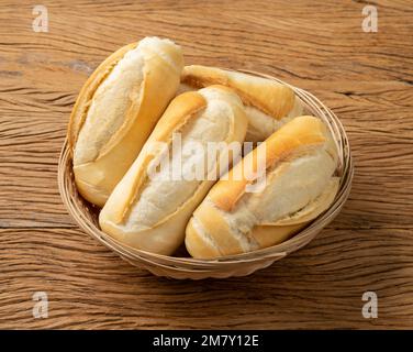 Französisches Brot, Salzbrot oder Pistole in einer Schüssel über einem Holztisch. Stockfoto