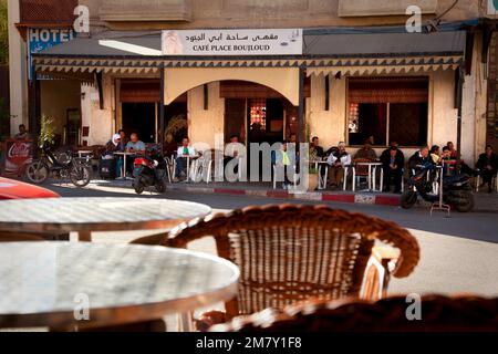 Fez, Marokko-25. April 2014: Gruppe von Personen, die an einem Tisch sitzen und sich an einem schönen Frühlingsnachmittag auf der Terrasse einer Bar in ein paar Drinks teilen Stockfoto