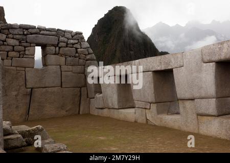 Der spirituelle Morgennebel erhebt sich über dem Inka Head Mountain in Machu Picchu mit Huana Picchu im Hintergrund. Stockfoto