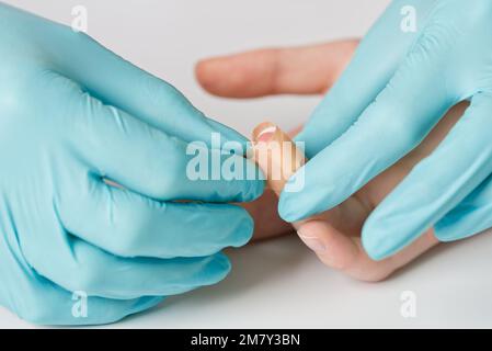 Arzt legt medizinisches Klebeband wasserfest Pflaster auf Schnittwunden am Finger. Stockfoto