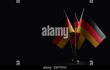 Kleine deutsche Nationalflaggen auf schwarzem Hintergrund. Stockfoto