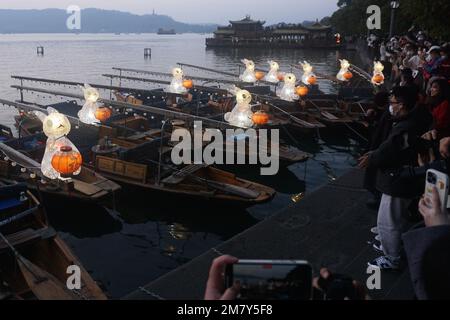 HANGZHOU, CHINA - 11. JANUAR 2023 - Eine große Anzahl von Bürgern und Touristen beobachtete und fotografierte handgezogene Boote, die mit Jade Rabbit Lant ausgestattet waren Stockfoto