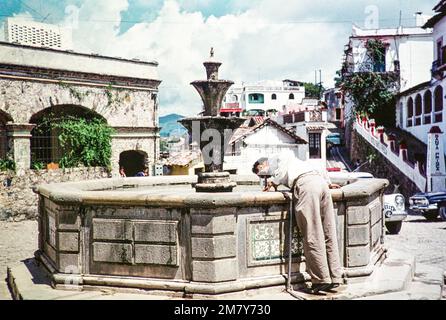 Mann trinkt Wasser aus Springbrunnen, Taxco, Bundesstaat Guerrero, Mexiko, 1961 Stockfoto