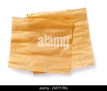Backpapier isoliert. Zerknitterte Stücke braunes Pergament oder Backpapier auf weißem Hintergrund. Draufsicht. Konstruktionselement. Stockfoto