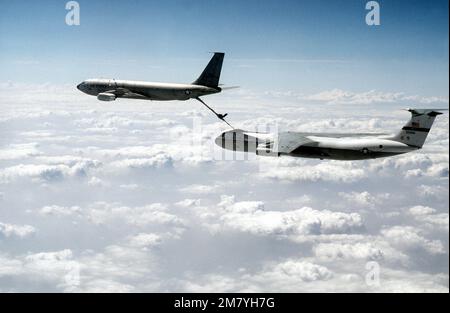 Eine Luft-zu-Luft-Ansicht von links eines KC-135A Stratotanker-Flugzeugs aus dem 97. Bombardement-Flügel, das ein C-141B Starlifter-Flugzeug aus dem 437. Military Airlift-Flügel betankt. Land: Unbekannt Stockfoto