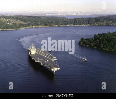 Steuerbordbogenansicht des nuklearbetriebenen Flugzeugträgers USS ENTERPRISE (CVN-65) im Gange. Die ENTERPRISE, auf dem Weg zum Hafen von San Francisco, war wegen Reparaturen und Modifikationen im Trockendock. Die Stadt Seattle ist im Hintergrund zu sehen. Basis: Puget Sound Bundesstaat: Washington (WA) Land: Vereinigte Staaten von Amerika (USA) Stockfoto