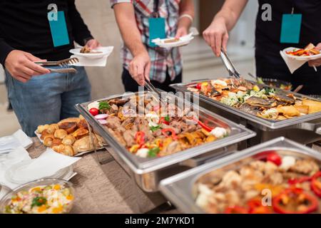 Leute wählen frisch zubereitete Speisen vom Büfetttisch aus. Stockfoto