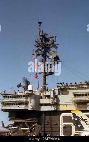 Vor dem Radarmast am Flugzeugträger USS KITTY HAWK (CV-63) ist ein Langstreckenradar SPS-49 montiert. Im Vordergrund ist ein Flugzeug der Kategorie E-2 Hawkeye Airborne Early Warning (AEW) zu sehen. Land: Unbekannt Stockfoto