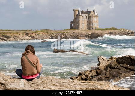 Wellen rund um das Turpault-Schloss, junge Frau, die auf Felsen sitzt, Quiberon, Morbihan, Bretagne, Fran Stockfoto