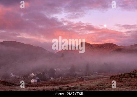 Blick auf den Sonnenaufgang über Elterwater Village in Richtung Langdale Pikes, Lake District England Stockfoto