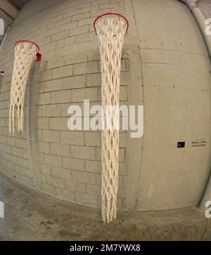 Handgewebter, bodenlanger Basketballkorb, roter Reifen mit bemalten Ziegelwänden Stockfoto