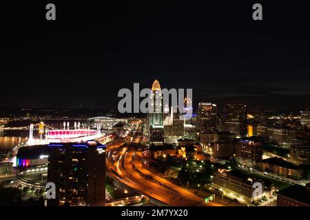Ein Blick aus der Vogelperspektive auf das Stadtzentrum von Cincinnati in Ohio bei Nacht, mit glühenden Straßenlaternen und langen Ampeln auf der Straße Stockfoto