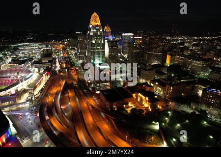 Ein Blick aus der Vogelperspektive auf das Stadtzentrum von Cincinnati in Ohio bei Nacht, mit glühenden Straßenlaternen und langen Ampeln auf der Straße Stockfoto