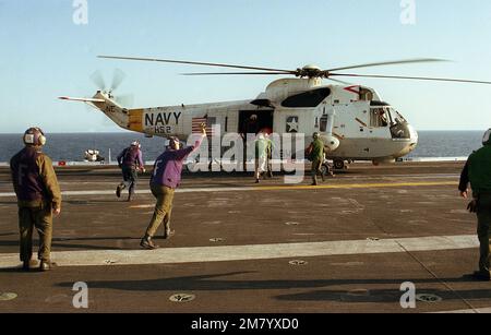 Besatzungsmitglieder besteigen einen SH-3A Sea King Hubschrauber vom Helicopter Anti-U-Boot-Geschwader 2 (HS-2) während einer Mann-über-Bord-Rettungsübung an Bord des Flugzeugträgers USS KITTY HAWK (CV 63). Das Geschwader ist dem Träger zugewiesen. Basis: USS Kitty Hawk (CV 63) Stockfoto