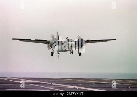 A C-1A Trader Cargo/Transport Aircraft nähert sich zur Landung an Bord des Flugzeugträgers USS KITTY HAWK (CV 63). Der Heckhaken am Flugzeug ist unten, um das Fanggerät auf dem Cockpit des Flugzeugträgers aufzufangen. Land: Unbekannt Stockfoto