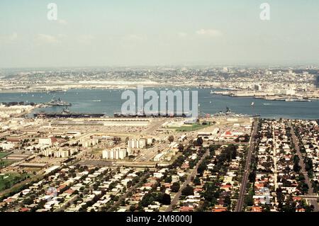 Luftaufnahme der Marineflugstation und der angedockten US-Marineschiffe. Sie sind (von rechts nach links): Das Schlachtschiff USS NEW JERSEY (BB 62) und der Flugzeugträger USS KITTY HAWK (CV 63) und USS RANGER (CV 61). Der nuklearbetriebene Führungsraketenkreuzer USS LONG BEACH (CGN 9) und der Führungsraketenzerstörer USS CHANDLER (DDG 996) sind im Hintergrund sichtbar. Basis: Marineflugstation, Nordinsel Bundesstaat: Kalifornien (CA) Land: Vereinigte Staaten von Amerika (USA) Stockfoto