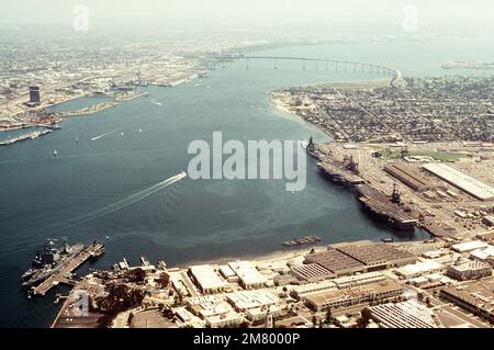 Luftaufnahme von Schiffen der US Navy, die an der Marineflugstation anlegen. Es handelt sich um das Schlachtschiff USS NEW JERSEY (BB 62), die Flugzeugträger USS KITTY HAWK (CV 63) und USS RANGER (CV 61), den nuklearbetriebenen geführten Raketenkreuzer USS LONG BEACH (CGN 9) und den geführten Raketenzerstörer USS CHANDLER (DDG 996) (im Uhrzeigersinn von oben rechts). Basis: Marineflugstation, Nordinsel Bundesstaat: Kalifornien (CA) Land: Vereinigte Staaten von Amerika (USA) Stockfoto