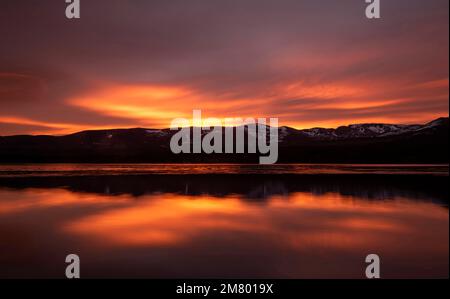 Sonnenaufgang über Loch Morlich und den Cairngorm Mountains, Cairngorms National Park in der Nähe von Aviemore, Badenoch und Strathspey, Schottland, Großbritannien Stockfoto