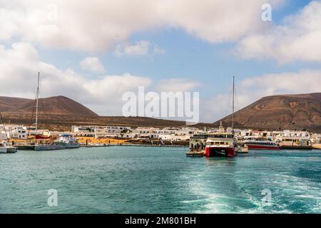 Caleta del Sebo, Spanien - 30. April 2022: Kleiner Hafen mit touristischen Fähren zwischen La Graciosa und Lanzarote, Kanarische Inseln Stockfoto